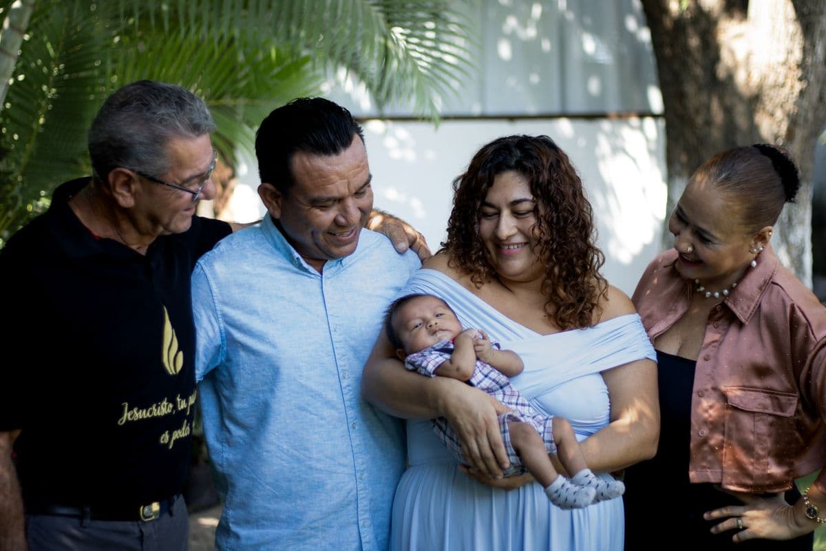 A multi-generational family smiling together outdoors