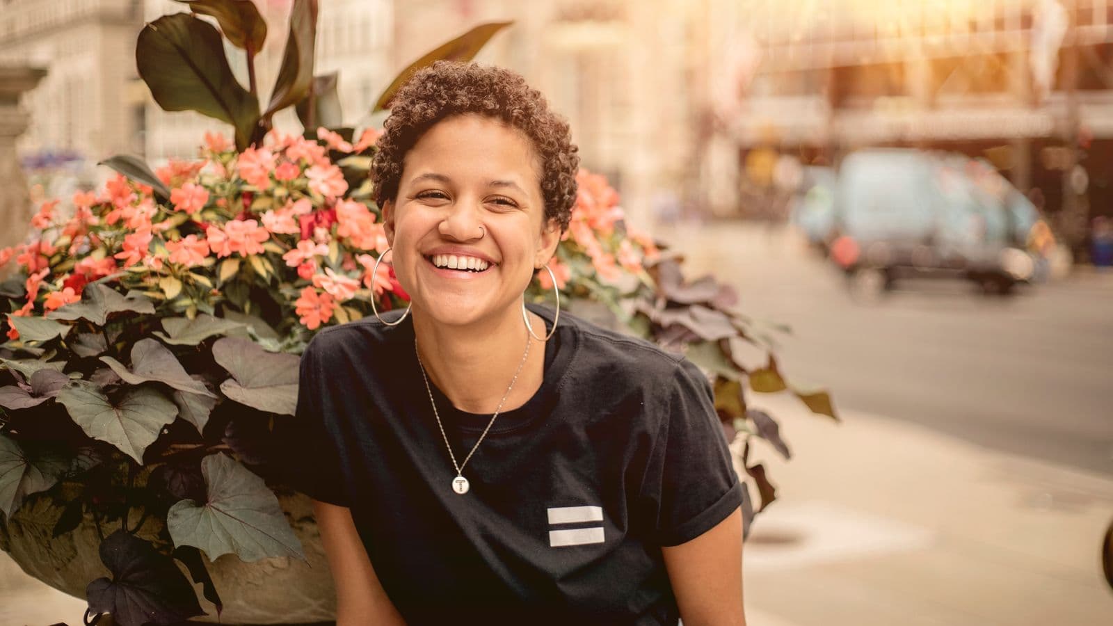A woman with a warm, welcoming smile in natural daylight