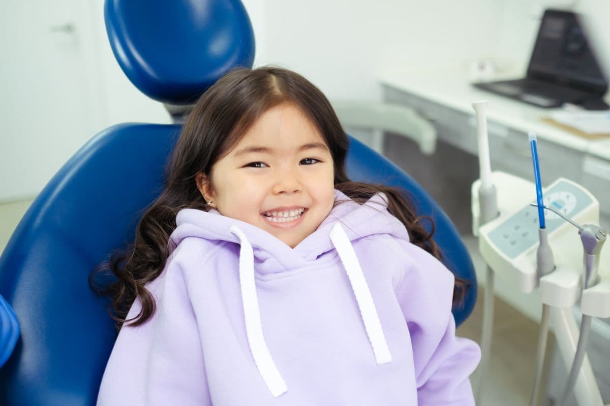 A child smiling happily at a friendly dental visit